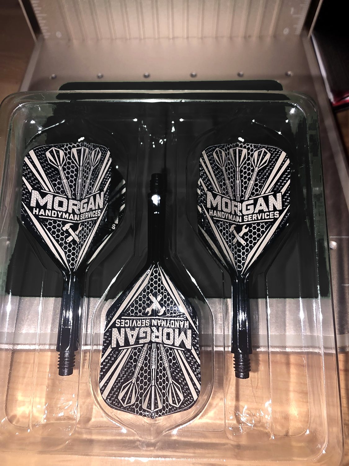 Three black flights engraved with the Morgan Handyman Services logo, in their tray