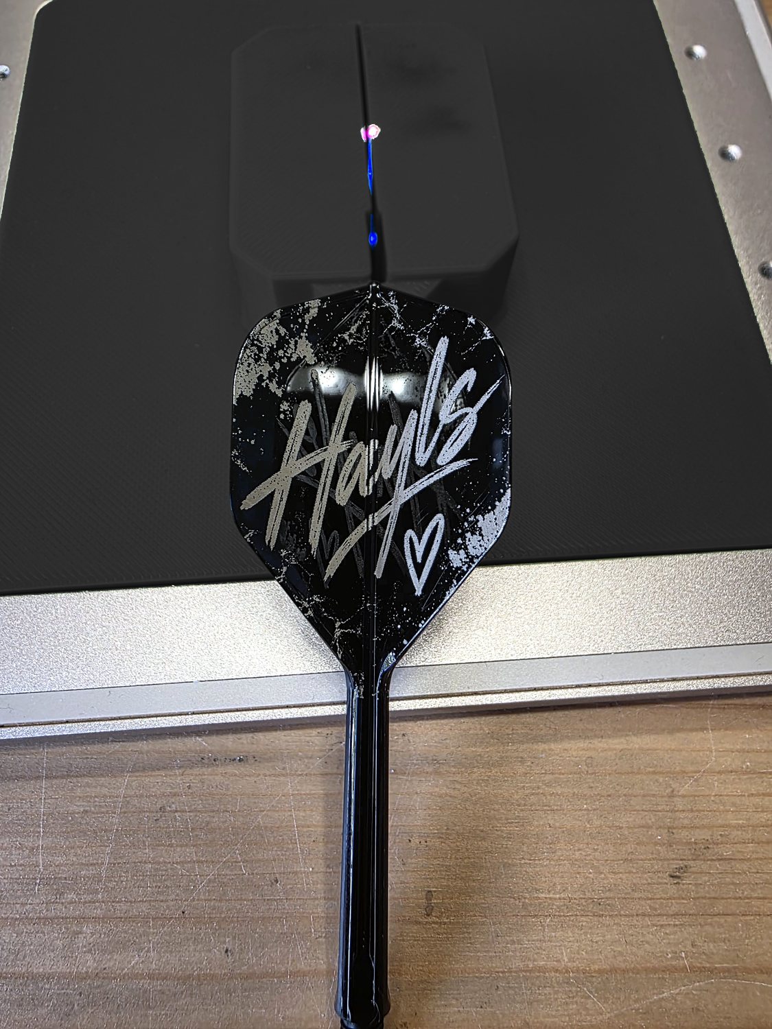 A black flight engraved with the name Hayls in white script and a small heart